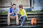 Young couple using digital tablet outdoors, Munich, Bavaria, Germany
