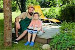 Father and son taking a break in the garden, Munich, Bavaria, Germany