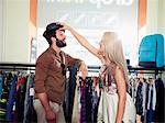 Young couple fooling around in clothing store