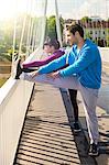 Young couple stretching on bridge, Osijek, Croatia