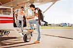 Young couple preparing  for start in private airplane