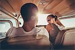 Young couple sitting in cockpit of propeller airplane