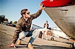 Pilot checking wing of propeller airplane