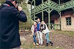 Man taking a picture of friends in front of mansion