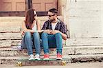 Young couple with skateboard taking a break