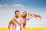 Happy couple walking by colza field, Tuscany, Italy