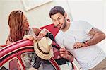 Young couple preparing for road trip in red car