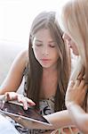 Two female university students using digital tablet together