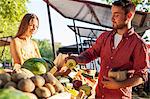 Male customer buying vegetables at market stall