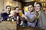 Friends toasting with beer in pub, Dorset, Bournemouth, England