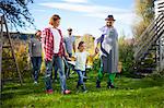 Family with wheelbarrow in garden, Munich, Bavaria, Germany