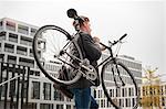 Young businessman carrying bicycle, Munich, Bavaria, Germany