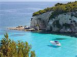 View from hillside over secluded Voutoumi Bay, solitary boat at anchor, Antipaxos, Paxi, Corfu, Ionian Islands, Greek Islands, Greece, Europe