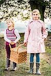 Two girls carrying picnic basket
