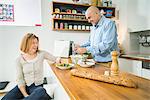 Senior couple in kitchen preparing salad