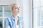 Blond woman looking through window