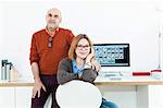 Senior couple at desk with computer monitor at home