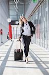 Businesswoman pulling luggage in modern lobby