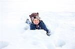 Little boy with bear costume playing in snow