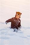 Boy with bear costume playing in snow