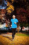 Male runner jogging in autumn park