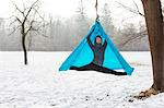 Young woman practicing aerial yoga outdoors