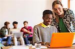 Smiling creative businesswomen working at laptop in office