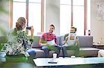 Creative businessman posing with photograph for coworker with instant camera in office