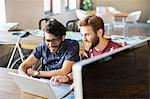 Casual businessmen working at laptop in office