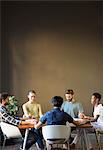 Serene casual business people holding hands with eyes closed at office table