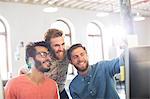 Smiling casual businessmen working at computer in office