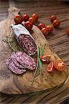 Close up of red sausage stick with tomatoes on a chopping board, Germany