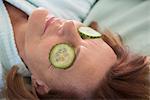 Senior woman with cucumber slices on her eyes, Munich, Bavaria, Germany