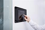 Man operating control panel on wall mounted, Munich, Bavaria, Germany