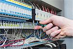 Close-up of electrician installing cable in distribution fusebox, Munich, Bavaria, Germany