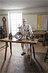 Senior sculptor with religious sculptures at workshop, Bavaria, Germany