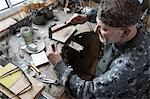 Senior male goldsmith hitting punches in workshop, Bavaria, Germany