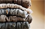 Close-up of stack of five cardigans, studio shot on brown background