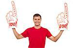 Young energetic fan showing his support by holding two large foam hands