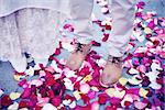 Bride and groom standing amongst rose petals