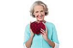 Senior woman holding heart shaped valentine gift