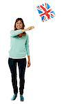 Woman waving UK flag, full length portrait.