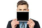 Young guy hiding his face with tablet pc