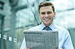 Business man reading news and smiling at camera