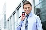 Smiling businessman holding his suit jacket on his shoulder