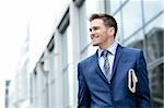 Young businessman holding a newspaper at outdoors