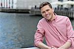 Young smiling man stands near railings