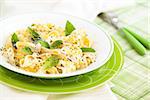 Italian pasta with cheese sauce and leaves of basil.