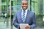 Confident african man working on digital tablet at outdoors