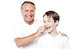 Cheerful father and son posing with positive smile